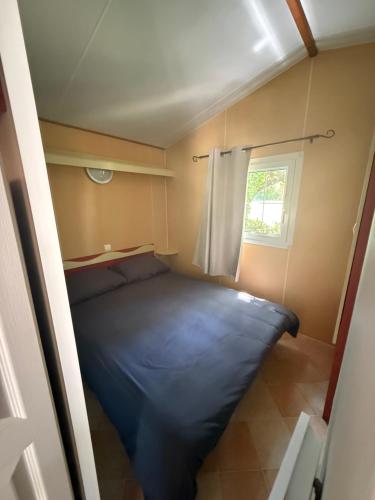 a bed in a small room with a window at Sous les étoiles de St georges in Lazer