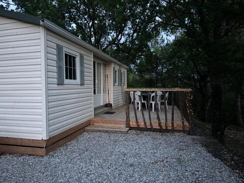 a house with a deck with a table and chairs at Sous les étoiles de St georges in Lazer
