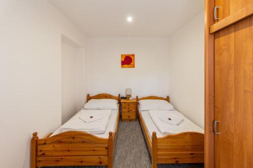 two twin beds in a small room with a door at Déli Terasz A Apartman Free parking, self-check-in anytime in Győr