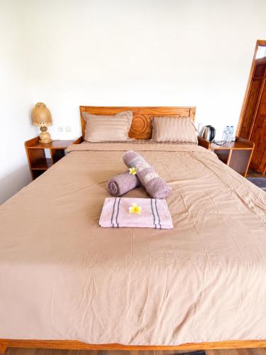 a bed with a stuffed animal on top of it at Eleen Bungalow in Tetebatu