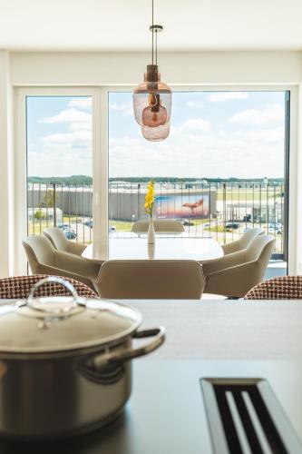 a dining room with a table and a large window at Boardinghouse Air Tech Campus - smart Check-in in Weßling