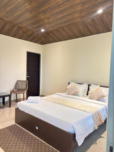 a bedroom with a large bed with a wooden ceiling at The Hillshade villa in Borpāni