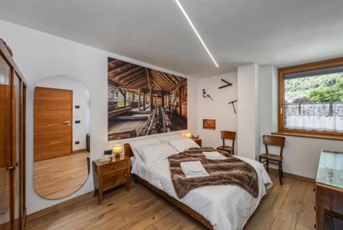 a bedroom with a bed and a large window at B&B Soreghina in Malè