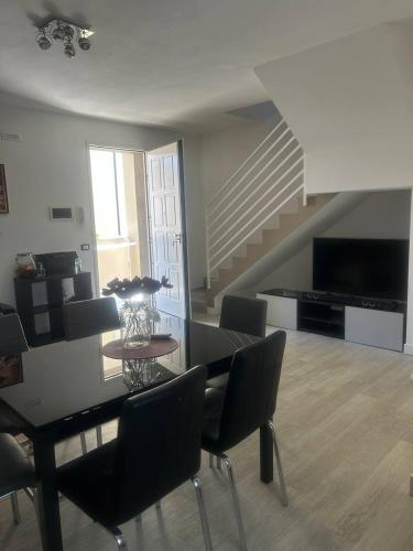 a dining room with a table and chairs and a staircase at Summer Nest in Cecina