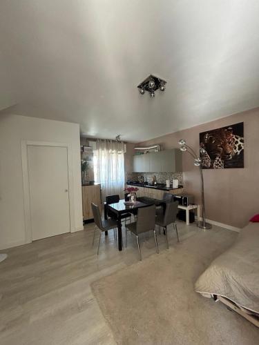 a living room with a table and chairs and a kitchen at Summer Nest in Cecina