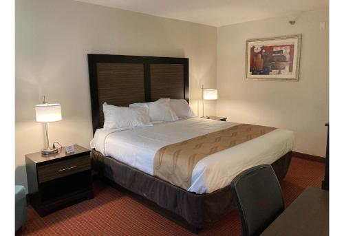 a hotel room with a large bed and two lamps at Motel 6 Elkhart, IN in Elkhart