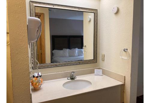 a bathroom mirror with a sink in a hotel room at Motel 6 Elkhart, IN in Elkhart