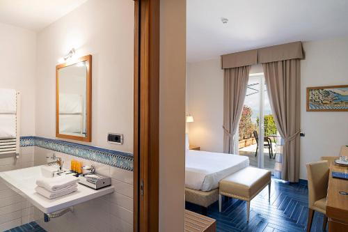 a hotel room with a bed and a bathroom at Hotel Raito in Vietri sul Mare