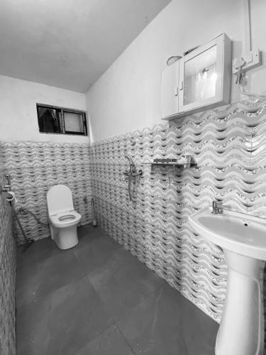 a bathroom with a toilet and a sink at Bravo Hills in Gauhāti