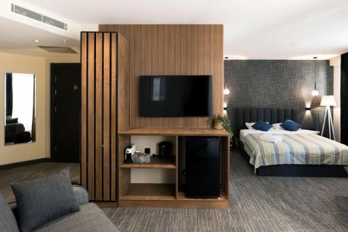 a hotel room with a bed and a flat screen tv at NOVA LUXE Hotel & Residences in Batumi