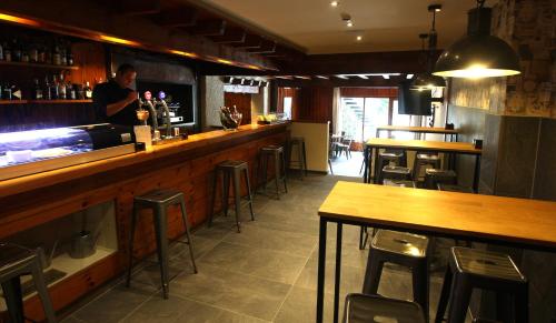 a man standing at a bar in a restaurant at Hotel & Spa Real Villa Anayet in Canfranc-Estación