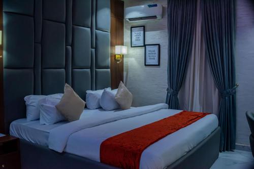 a bedroom with a large bed with pillows at De Grand Vale Hotel and Suite in Abuja