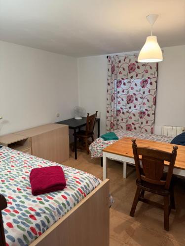 a bedroom with a bed and a wooden table and a dining room at El Doblao del Rey in Torrejón del Rey
