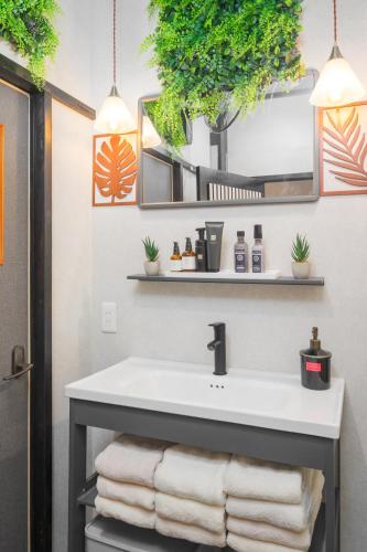 a bathroom with a sink with towels and plants at SNUGGLE2222 Hakone Iriuda in Odawara