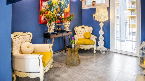 a living room with two chairs and a painting on the wall at Hotiday Ferrara Centro in Ferrara