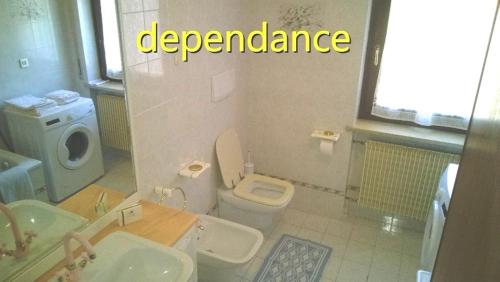 a bathroom with a sink and a toilet with the words dependence at Albergo alla Posta B&B in Roana