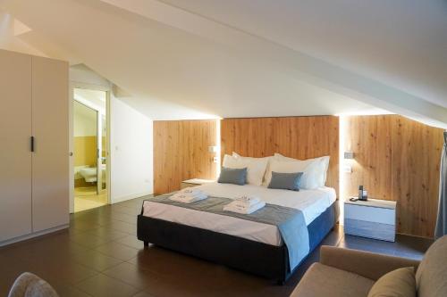 ein Schlafzimmer mit einem großen Bett und einer Couch in der Unterkunft Hotel F52 in Parma