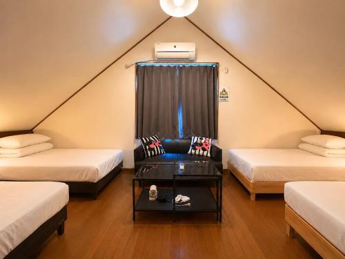 a attic room with two beds and a table at Daiwa House BBQ 琵琶湖徒步3分 無料駐車4台プロジェクター in Takashima