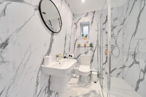 a bathroom with a sink and a toilet and a mirror at Central Ripon - Sleeps 3 - Garden - Pet Friendly in Ripon