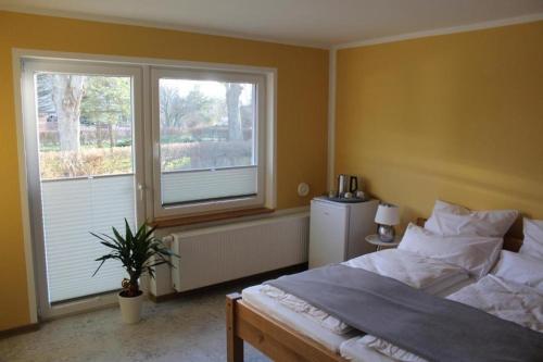a bedroom with a large bed and two windows at Ferienwohnung Vorsicht Hotel in Deyelsdorf