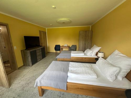 a hotel room with two beds and a television at Ferienwohnung Vorsicht Hotel in Deyelsdorf