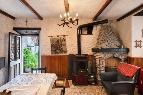 a living room with a stone fireplace and a table at Casa Fenera in Valduggia