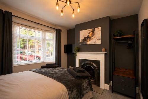 a bedroom with a bed and a fireplace at Super Modern 3 bedroom semi-detached. in Rugby