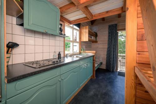 a kitchen with blue cabinets and a counter top at Kampeerhut met gedeeld sanitair in Wintelre