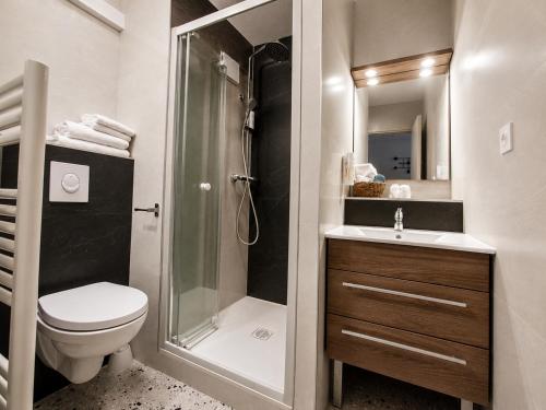a bathroom with a shower and a toilet and a sink at Hôtel-Restaurant La Belle Poule - in Rochefort