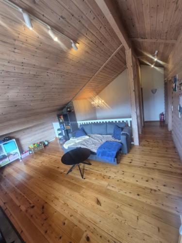 a living room with a blue couch and wooden floors at Villa Strand in Skodje