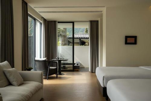 a hotel room with a bed and a couch at Magnolia Maison in Garze