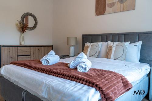 a bedroom with a large bed with towels on it at Noua Suites in Braşov
