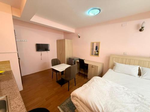 a bedroom with a bed and a desk and a table at Lux Apartment in Kathmandu