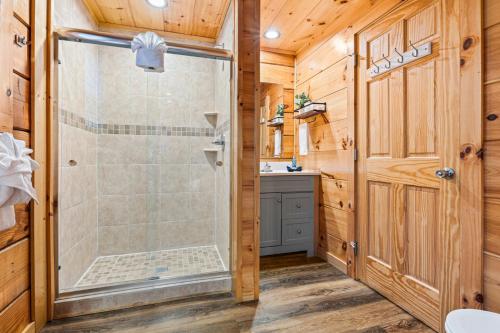 a bathroom with a shower and a sink at Rustic Mountain Retreat by Ghosal Luxury Lodging in Pigeon Forge