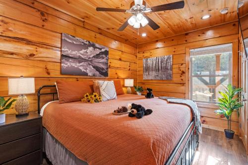 a bedroom with a bed with a ceiling fan at Rustic Mountain Retreat by Ghosal Luxury Lodging in Pigeon Forge