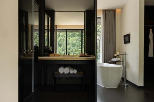 a bathroom with a tub and a large mirror at Magnolia Maison in Garze
