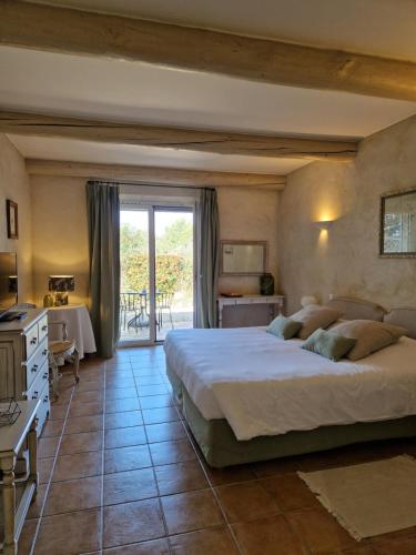 a bedroom with a large bed and a table at Mas de Fauchon - Teritoria in Saint-Cannat