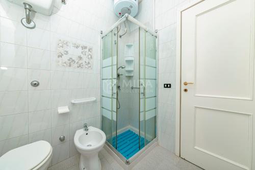 a bathroom with a glass shower and a toilet at Villa Cesare in Torre Specchia Ruggeri