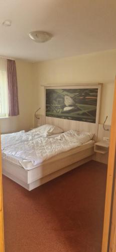 a bed in a bedroom with a painting on the wall at Ferienpark Retgendorf in Retgendorf