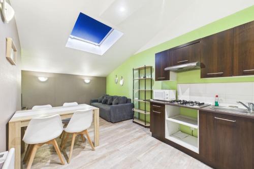 a kitchen and living room with a table and chairs at Le Cocoon Fuchsia in Romilly-sur-Seine