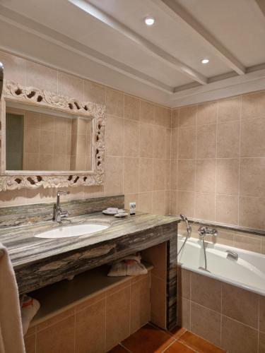 a bathroom with a sink and a tub and a mirror at Mas de Fauchon - Teritoria in Saint-Cannat