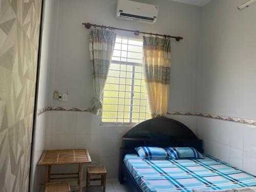 a small bedroom with a bed and a window at Mecong Homestay in Ben Tre