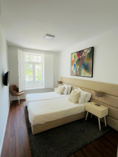 a bedroom with two beds and a painting on the wall at Casa Rosa Sousa in Felgueiras