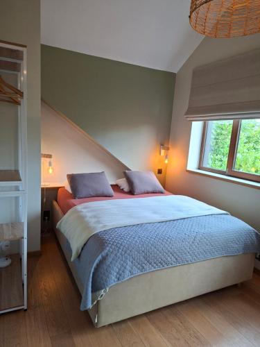 a bedroom with a large bed with two pillows at La Cachette de Simone in Spa