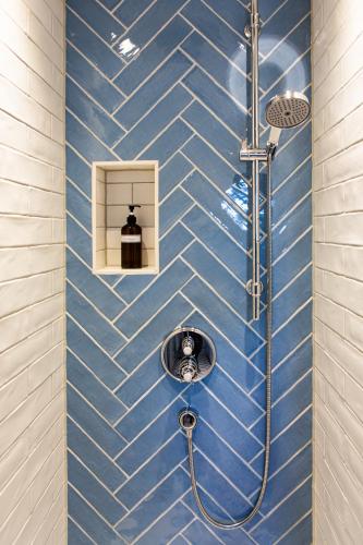 a blue tiled bathroom with a shower at Villa Weißbach - Haus Hilda in Flöha