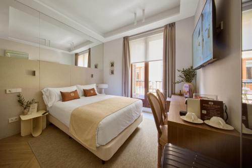 a hotel room with a large bed and a desk at Glinter Barrio de las Letras - Apartments in Madrid