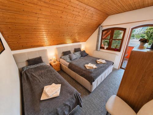 a bedroom with two beds in a room with a ceiling at Berni apartman in Badacsonytomaj