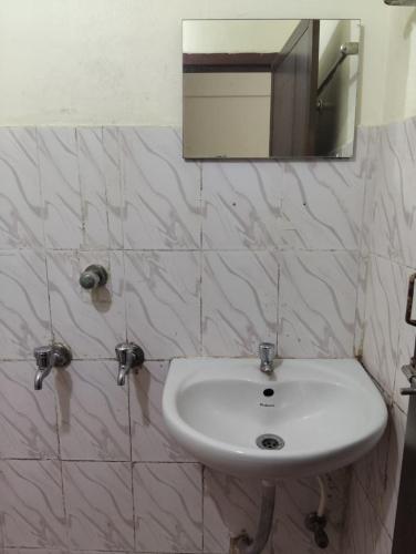 a white sink in a bathroom with a mirror at R K Residency Formerly Gamas in Trivandrum