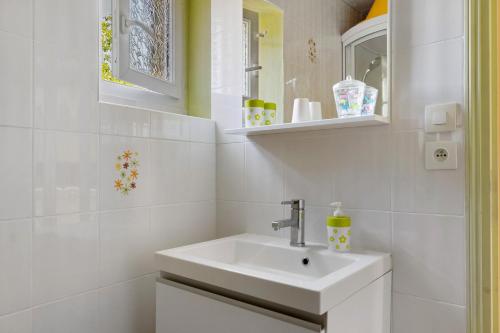 a white bathroom with a sink and a mirror at Gîte Mélany in Chargé