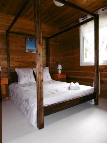a bedroom with a bed in a wooden cabin at Le ptit coin mont vert in Saint-Pierre